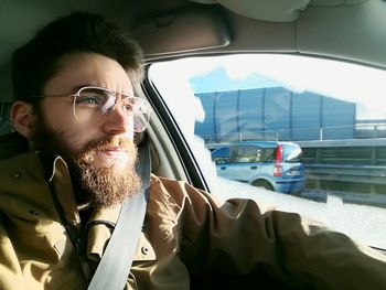 Portrait of young man sitting in car