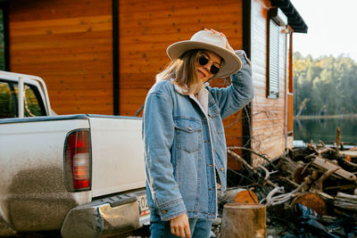 Midsection of woman wearing hat standing against bus