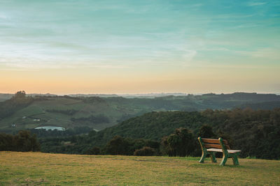 Lone bench on lawn and wooded valley near bento goncalves. brazil.