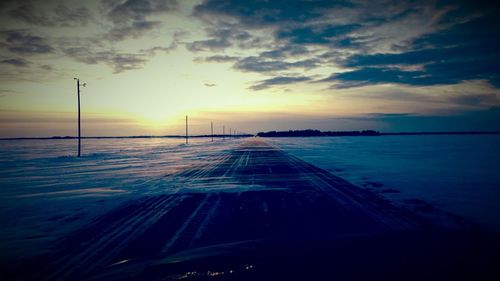 Scenic view of road against sky at sunset