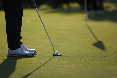 Low section of man standing on golf course