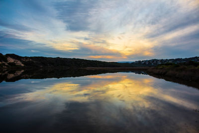 Scenic view of lake against sky during sunset.