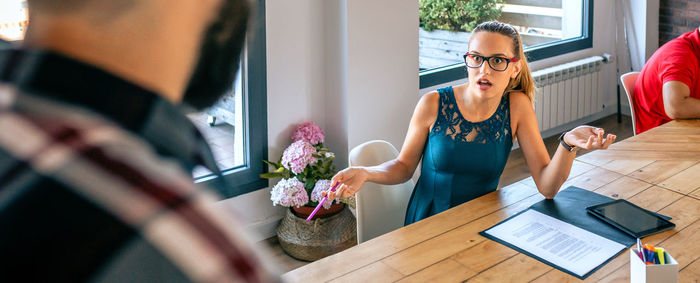 Side view of woman using mobile phone while sitting at home