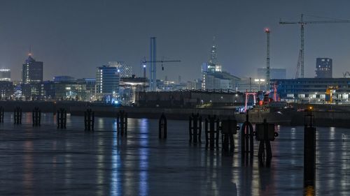 Illuminated port of hamburg against sky at night