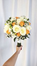 Close-up of hand holding rose bouquet