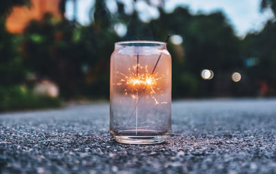 Close-up of sparklers burning in jar on road