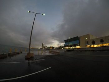 Empty road against sky in city at dusk