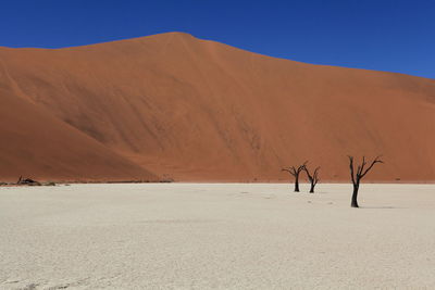 View of desert against clear blue sky