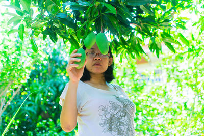 Midsection of woman holding leaves outdoors