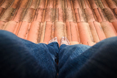 Low section of man standing on roof