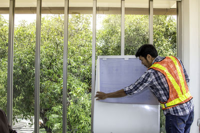 Side view of man working at window