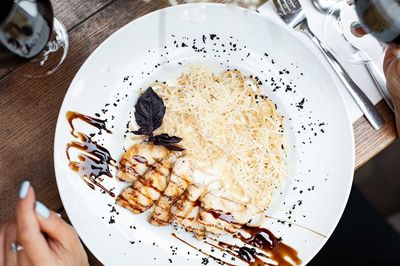 High angle view of person holding bread in plate