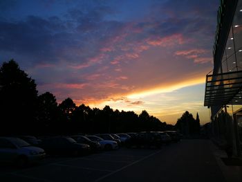 Cars on road against sky during sunset