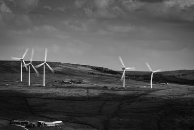 Windmills on landscape against sky