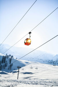 Snow covered power lines against sky