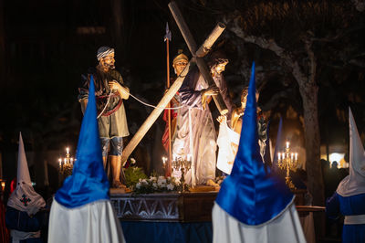 Rear view of woman wearing traditional clothing hanging at night