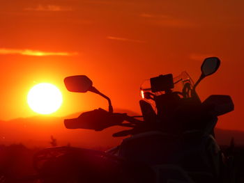 Silhouette people against orange sky during sunset