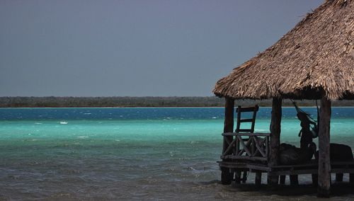 Built structure on beach against clear sky