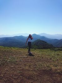 Rear view of woman standing on mountain landscape