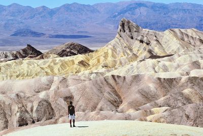 Rear view of man walking on mountain road