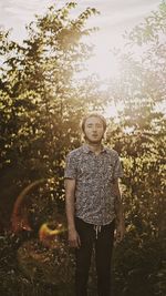 Portrait of young woman standing in forest