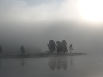 Scenic view of lake against sky at foggy weather