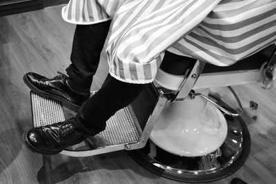 Low section of man sitting on chair in salon