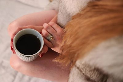 Midsection of woman holding coffee cup