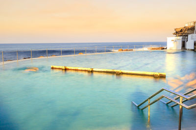 View of swimming pool by sea against sky