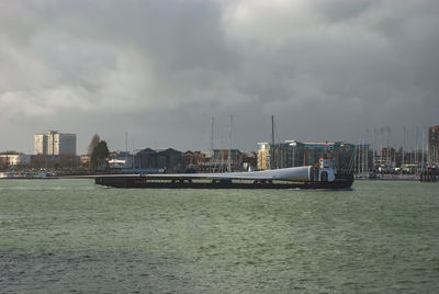 Scenic view of sea by buildings against sky