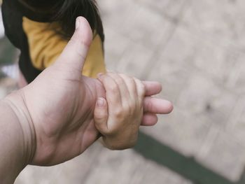 Cropped image of person holding hand of girl