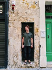 Full length of man standing against building