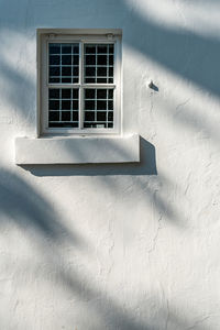 Low angle view of window on white wall