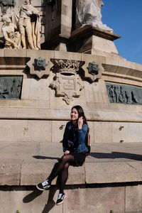 Full length portrait of woman against historic building