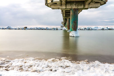 Bridge over sea against sky during winter