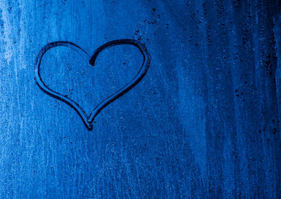 Close-up of heart shape on blue wall