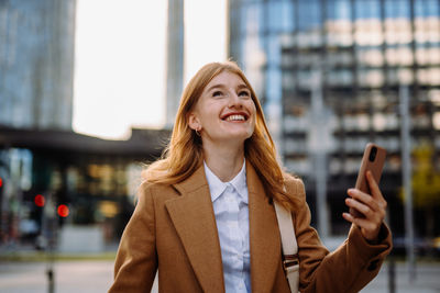 Young woman using mobile phone in city