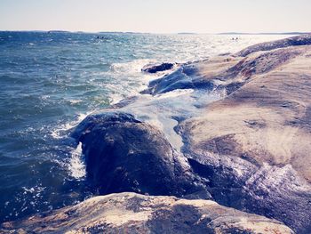 Scenic view of rocks in sea against sky