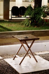 Empty chairs and table in yard against building