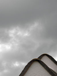 Low angle view of building against cloudy sky