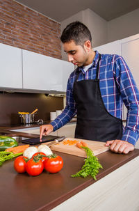Young man preparing food on cutting board
