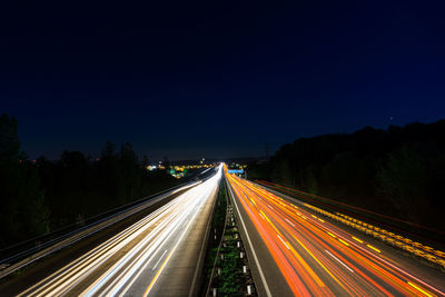 High angle view of light trails on highway at night