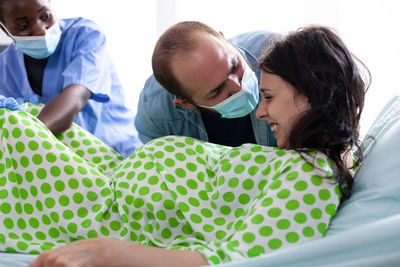 Man motivating woman in labour room at hospital