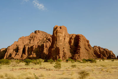 Rock formations on arid landscape against clear sky