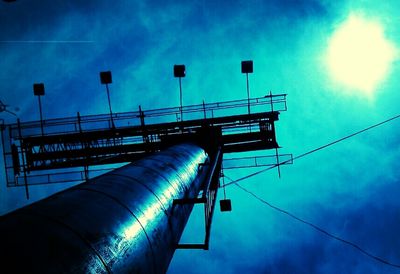 Low angle view of electricity pylon against blue sky