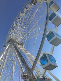 Low angle view of ferris wheel against clear blue sky