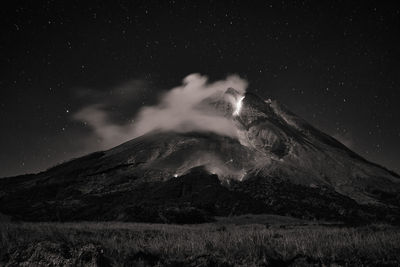 Scenic view of snowcapped mountain against sky at night