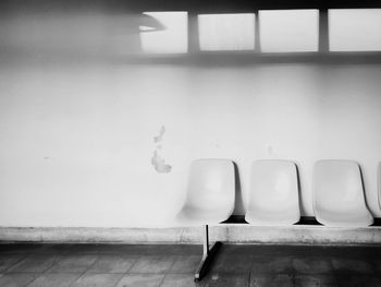 Empty chairs and table against wall at home