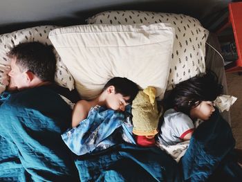 High angle view of siblings sleeping on floor