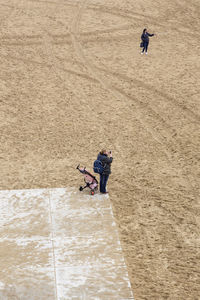 High angle view of people walking on sand